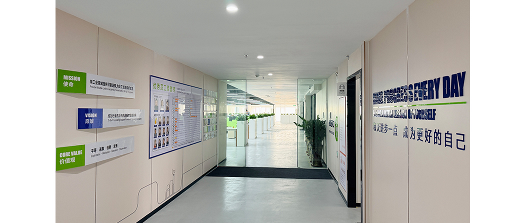 Close-up of company branding wall featuring Google Wire Company logo and slogan in a modern lobby setting.